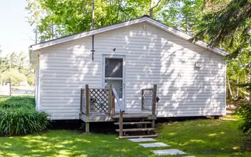 Pinegrove, a white three-bedroom cottage, seen from the lawn