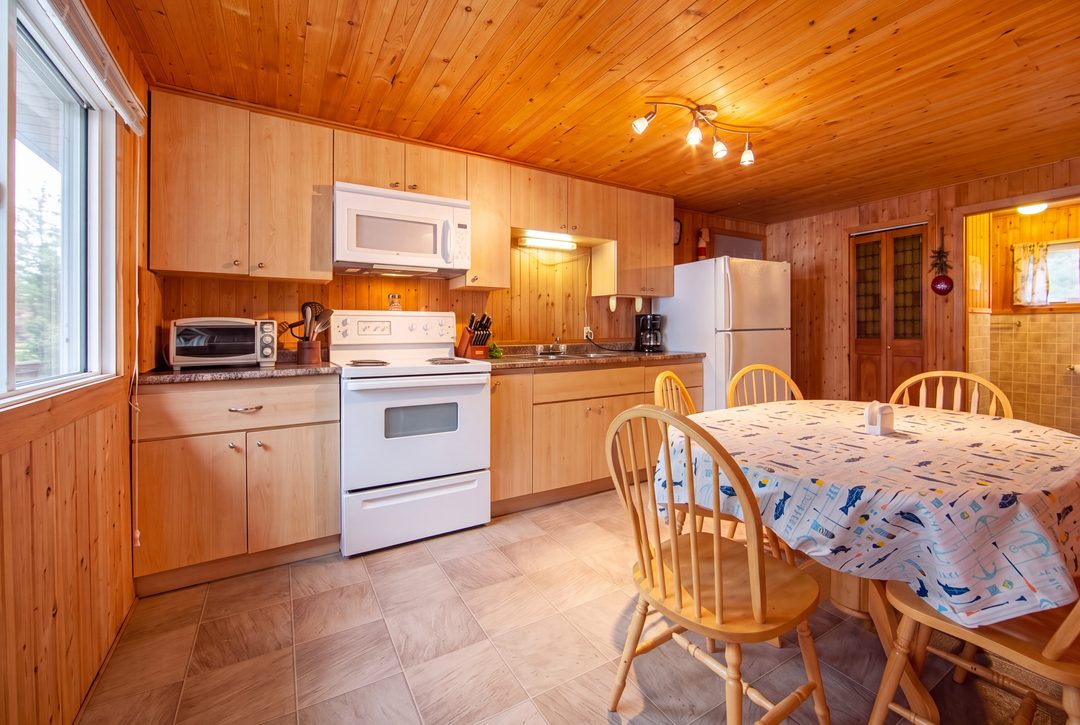 Pinegrove: the kitchen with a stove, microwave and dining table