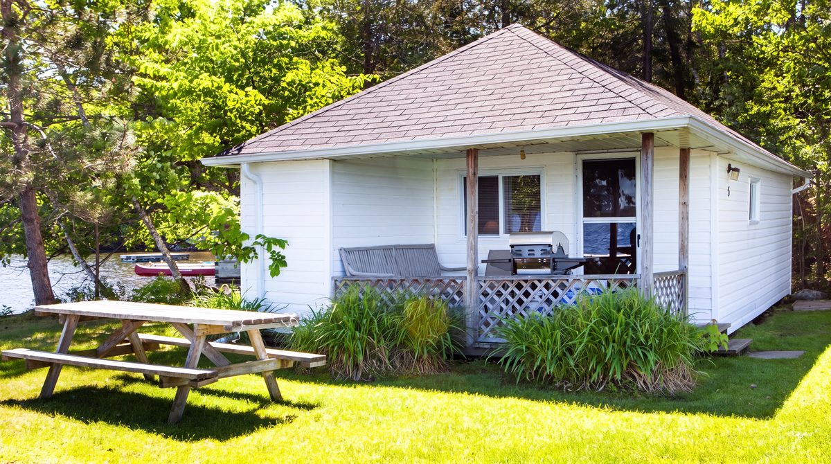 Peaceful Point, a white cottage with a covered porch and a picnic table