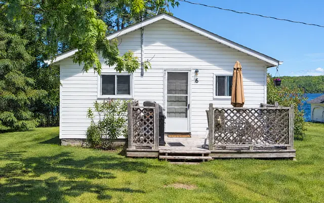 Lake Breeze, a white cottage with a deck and a patio umbrella