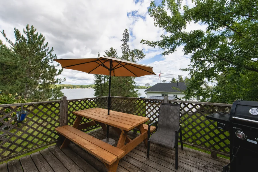 Eagle's Nest: a picnic table under an umbrella on the raised deck above the lake