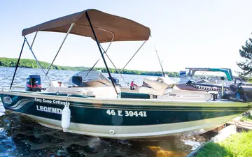 The Legend S fishing boat with a sun cover, tied up at the shore