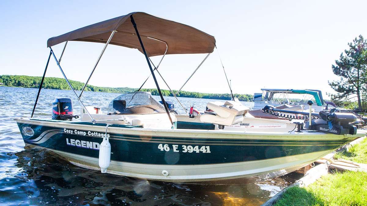 The Legend S fishing boat with a sun cover, tied up at the shore