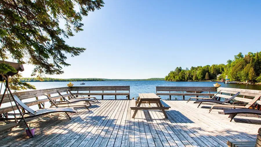 The lakeside sun deck with lounge chairs and picnic tables on a sunny day