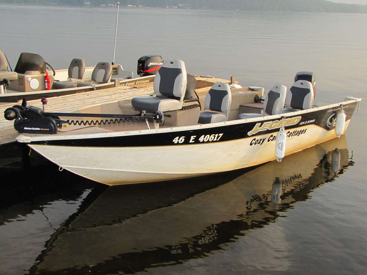 A Cozy Camp fishing boat moored on still water at the dock