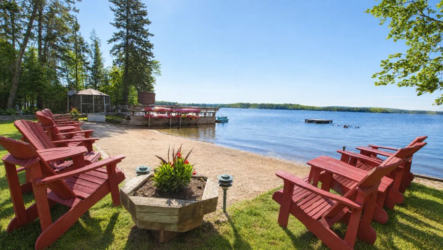 Adirondack chairs on the sandy beach at Cozy Camp, looking out over Lake Nosbonsing